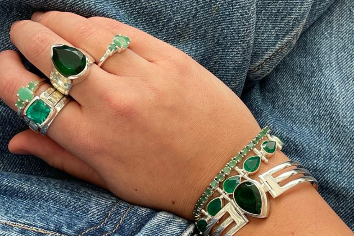 Close-up of emerald gemstone jewellery on linen with natural light, representing its meaning and zodiac benefits