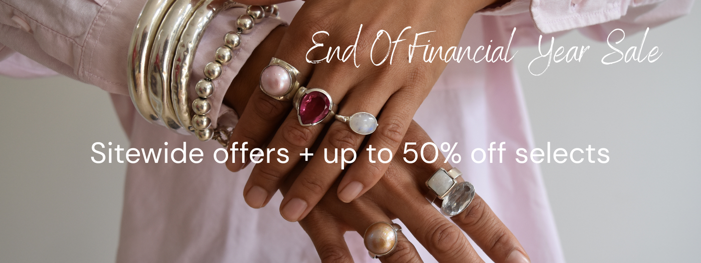 Woman wearing chunky silver bangles and bold gemstone rings – End of Financial Year jewellery sale, sitewide offers and up to 50% off selected pieces.