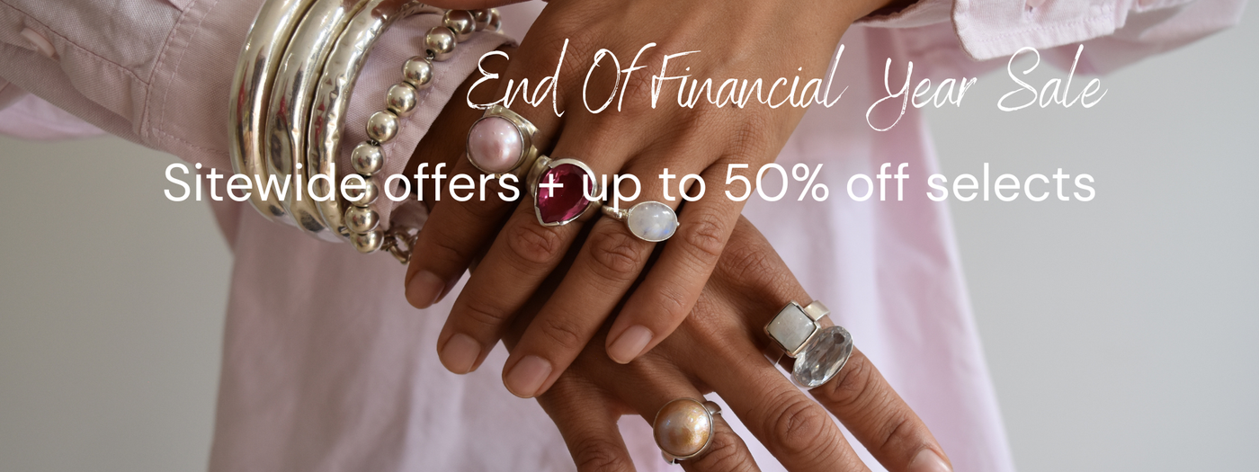 Woman wearing chunky silver bangles and bold gemstone rings – End of Financial Year jewellery sale, sitewide offers and up to 50% off selected pieces.